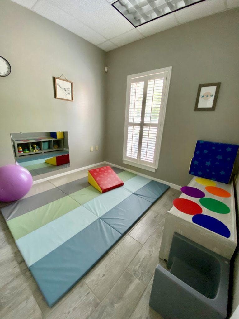 Colorful therapy room with pastel mats and play equipment